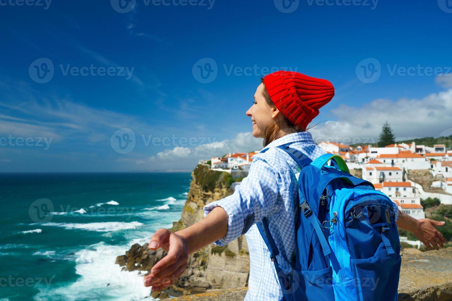 Woman with a backpack behind her back is spinning her arms out to the sides photo