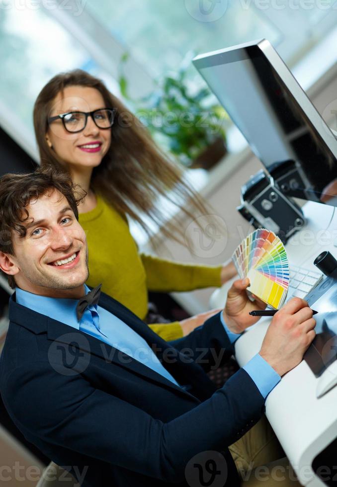 Young colleague looking to a color paint palette at home office photo