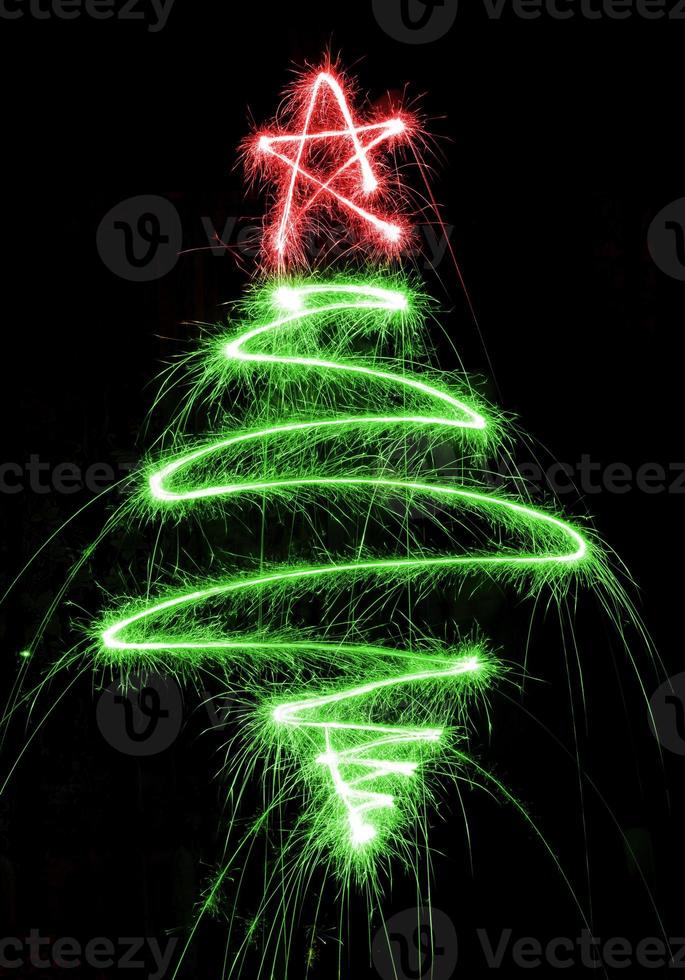 Christmas tree made by sparkler on a black photo