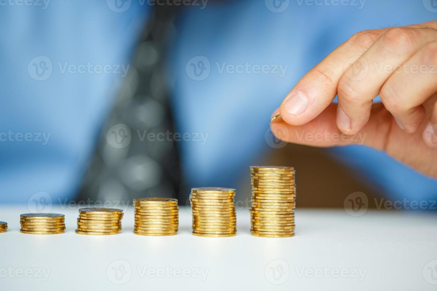 masculino mano apilado oro monedas dentro creciente columnas foto