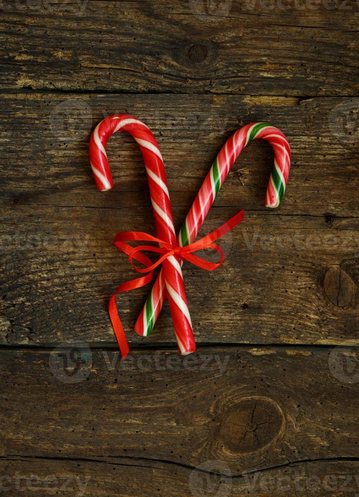 Closeup of two old fashioned candy canes on a rustic wooden background photo