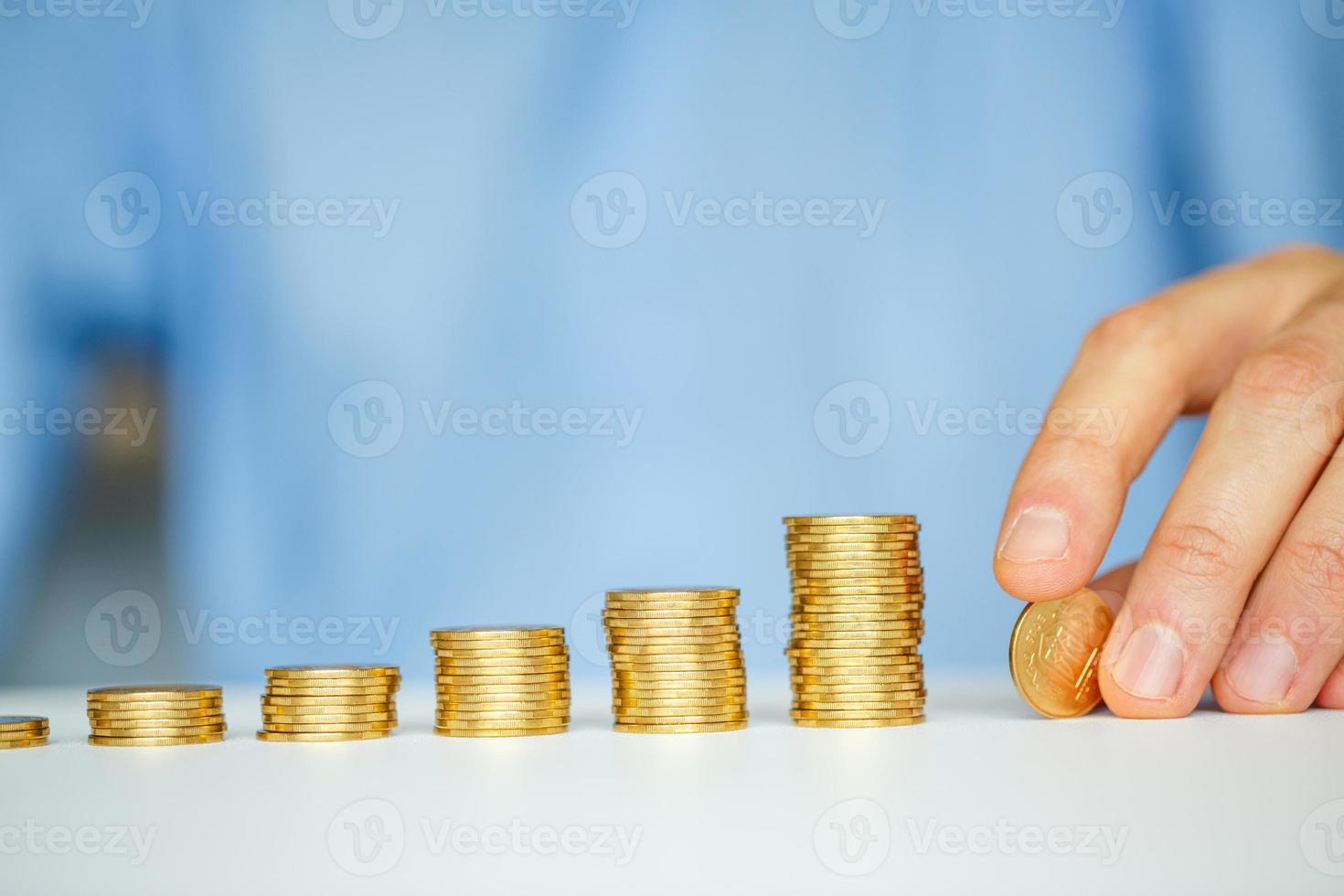 masculino mano apilado oro monedas dentro creciente columnas foto