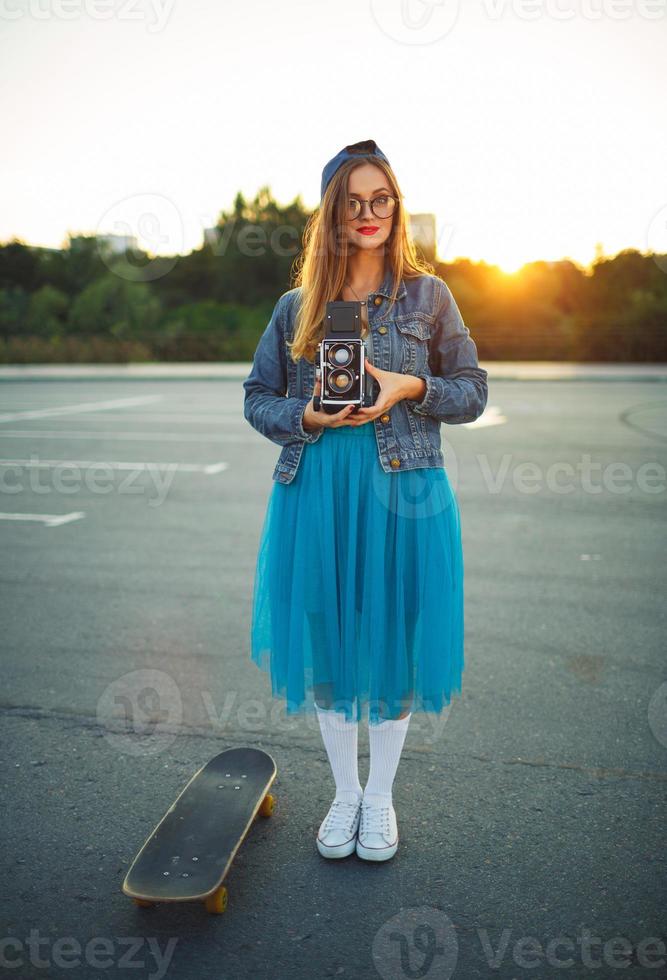 Summer lifestyle portrait of hipster girl with old camera photo