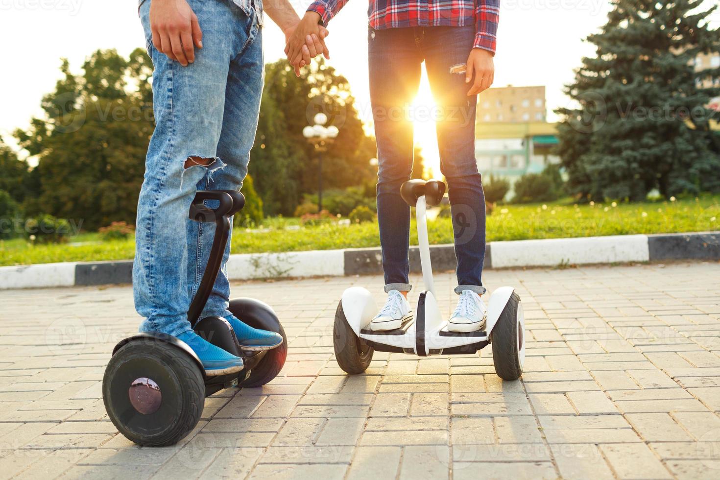 A young couple riding hoverboard - electrical scooter, personal eco transport, gyro scooter, smart balance wheel photo