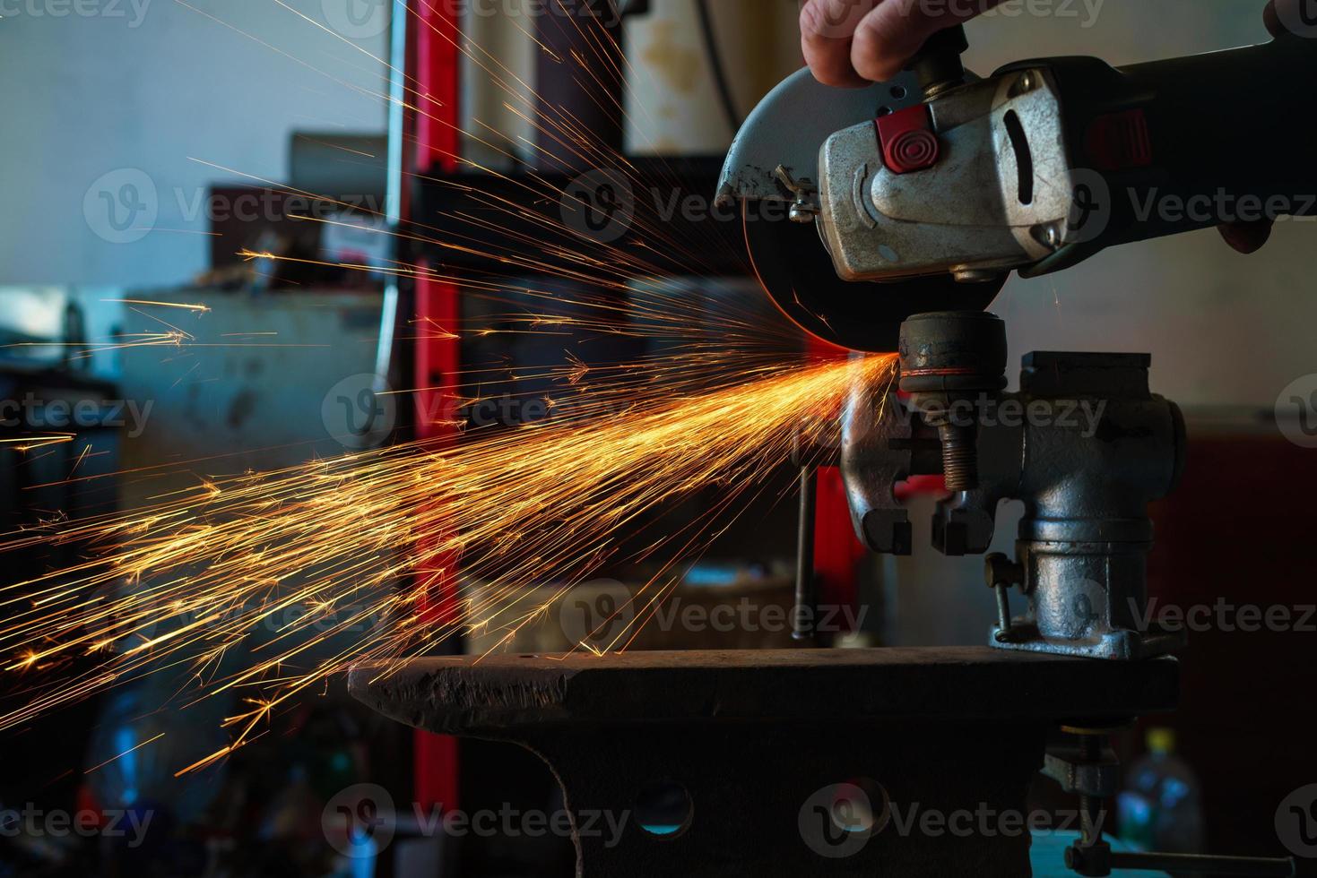 Angular grinding machine is cutting the metal and a lot of sparks photo