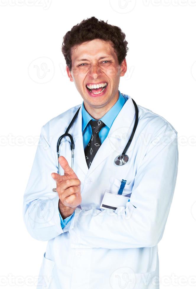 Portrait of a smiling male doctor showing finger at you on white photo