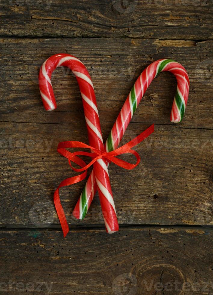 Closeup of two old fashioned candy canes on a rustic wooden background photo