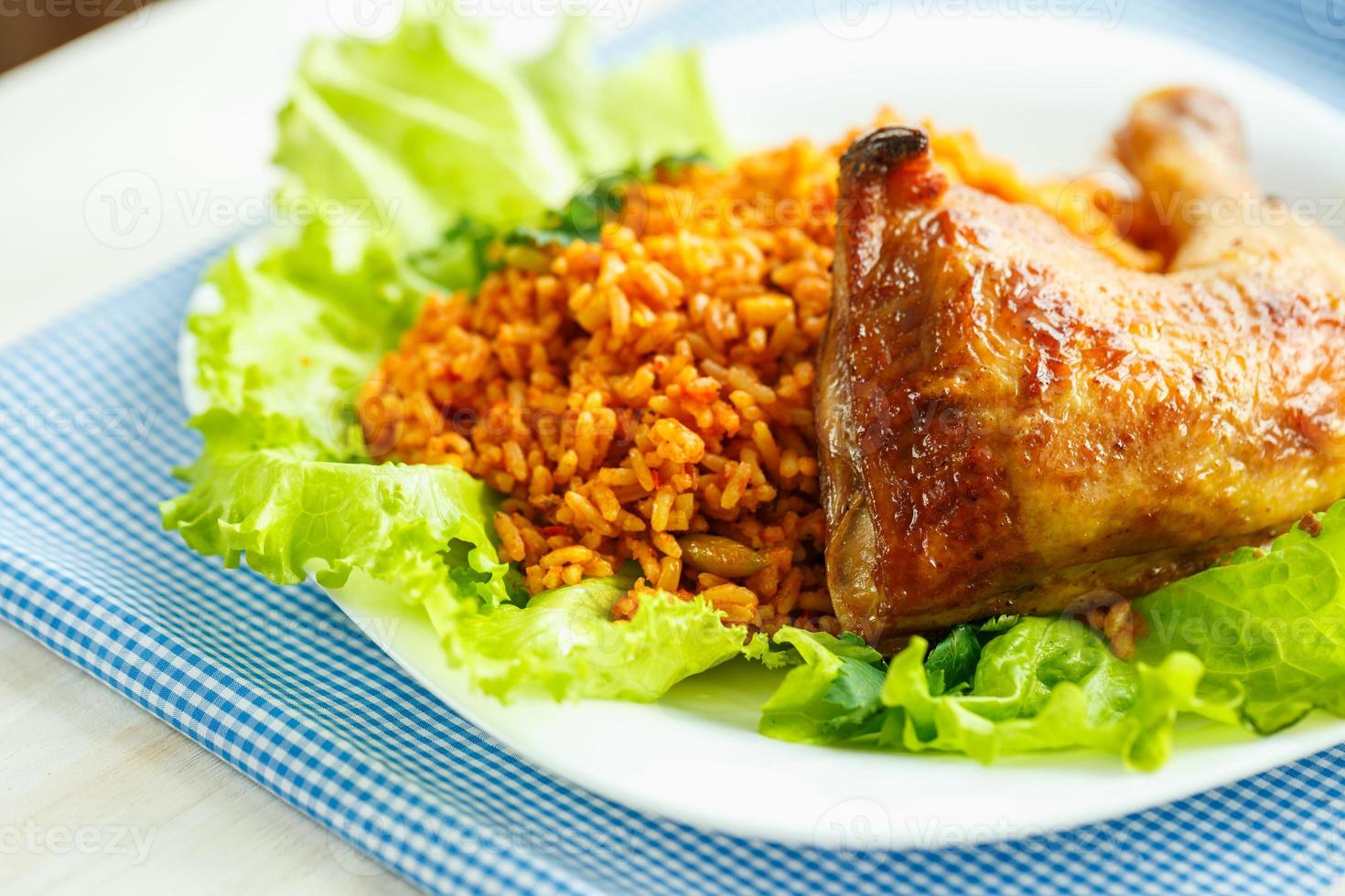 delicioso plato de pollo muslo con arroz y ensalada hojas foto