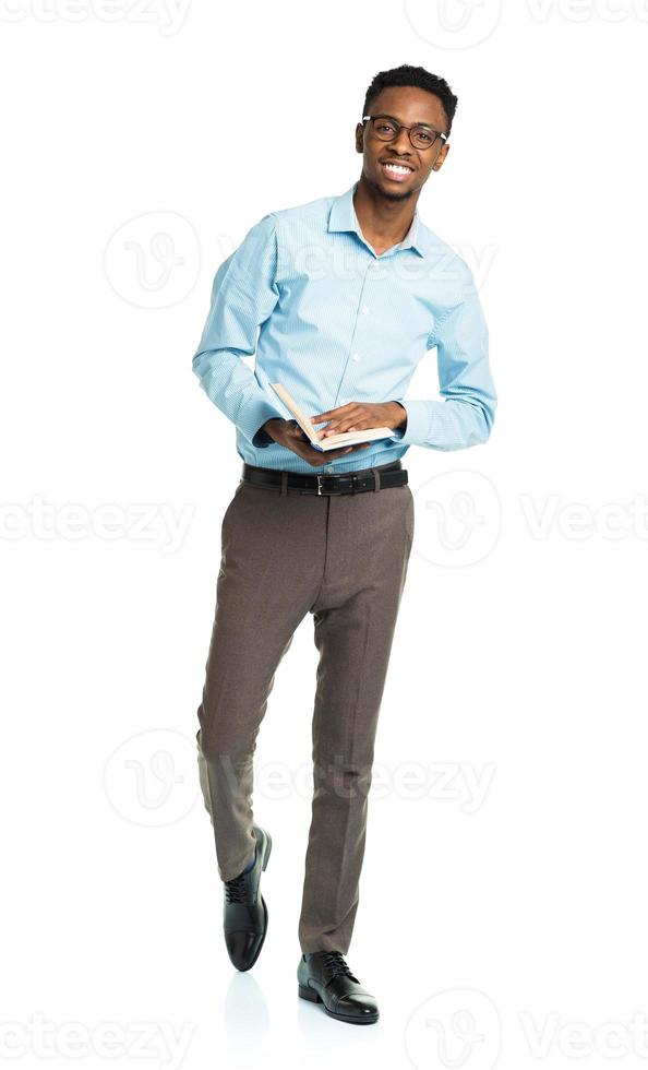 Happy african american college student with book in his hands standing on white photo