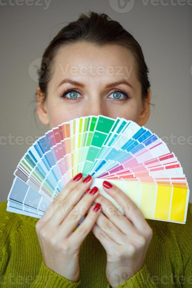 Woman in a glasses looking to a color paint palette photo