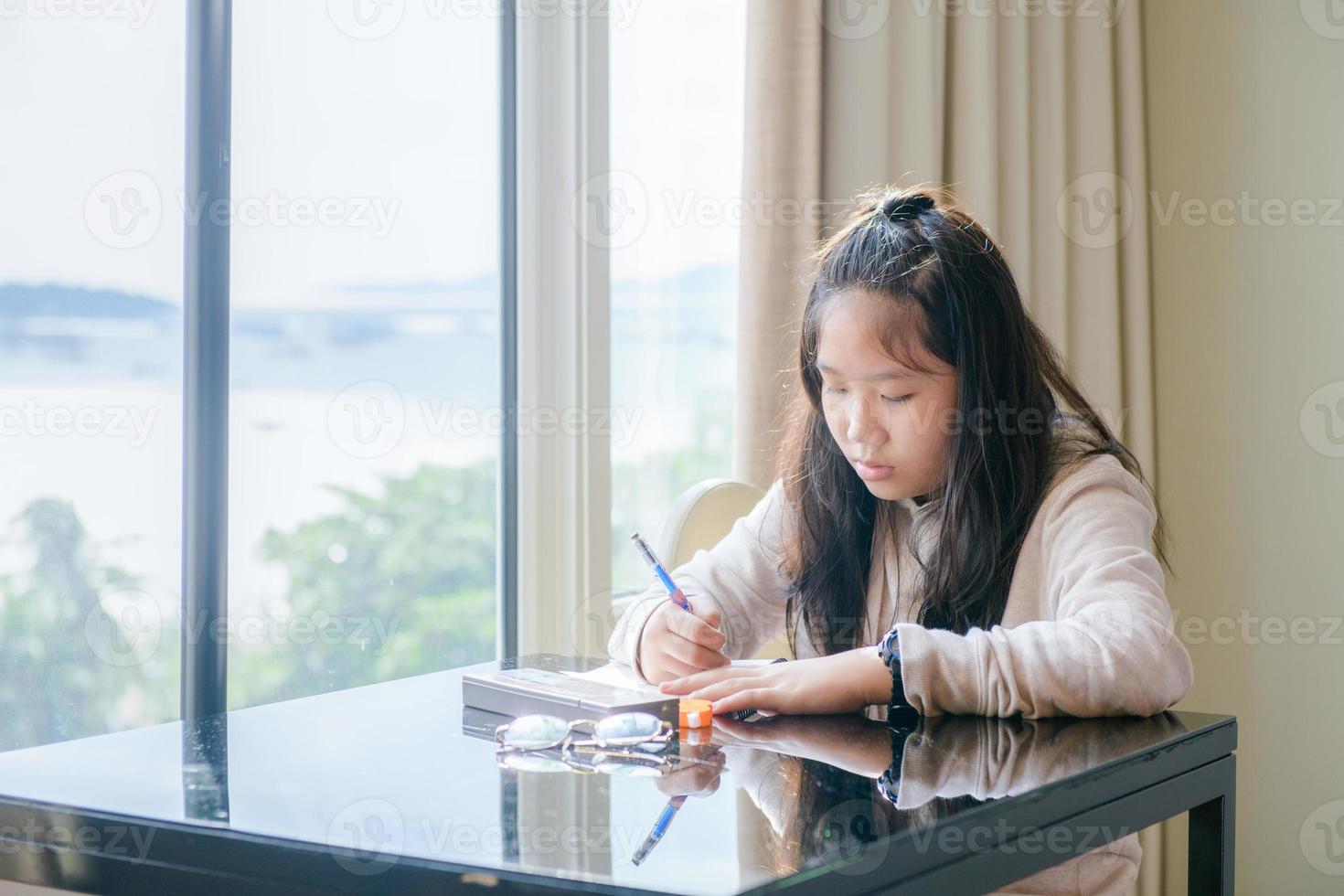 Cute girl sits and writes a travel diary in a hotel room. travel concept photo