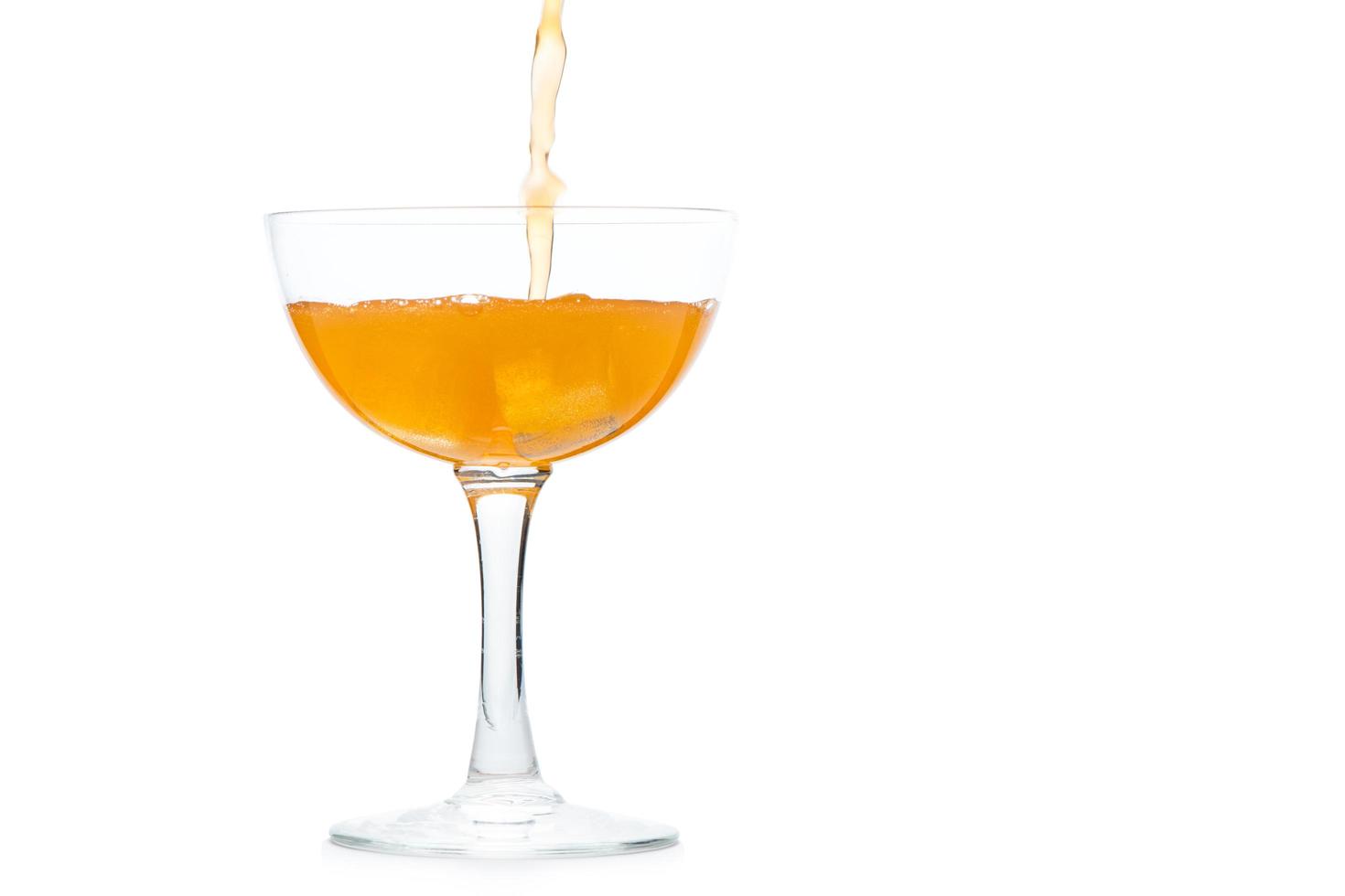 pour orange soda into Margarita glass isolated on white background, photo