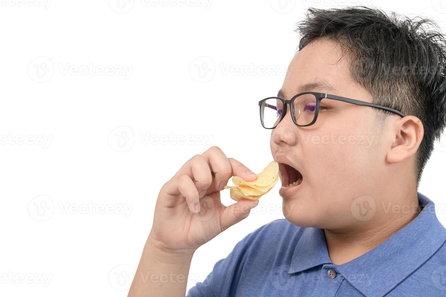 Obese fat boy eating potato chips isolated on white background, junk food concept photo