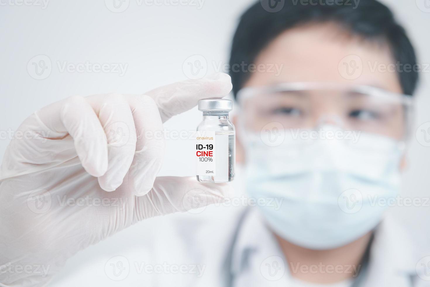 Development and creation of a coronavirus vaccine COVID-19. Young doctor with a stethoscope holding COVID-19 vaccine on white background. photo