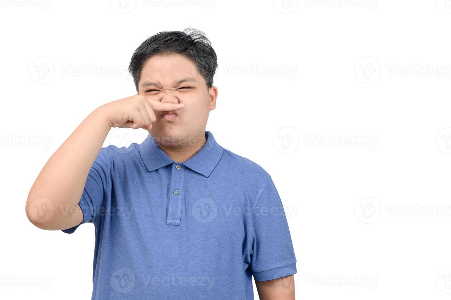 Asian child boy with disgust on face pinches his nose something stinks bad smell i photo