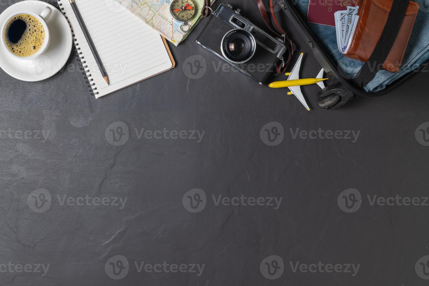 Prepare a suitcase,  vintage camera,  notebook, map and black coffee photo