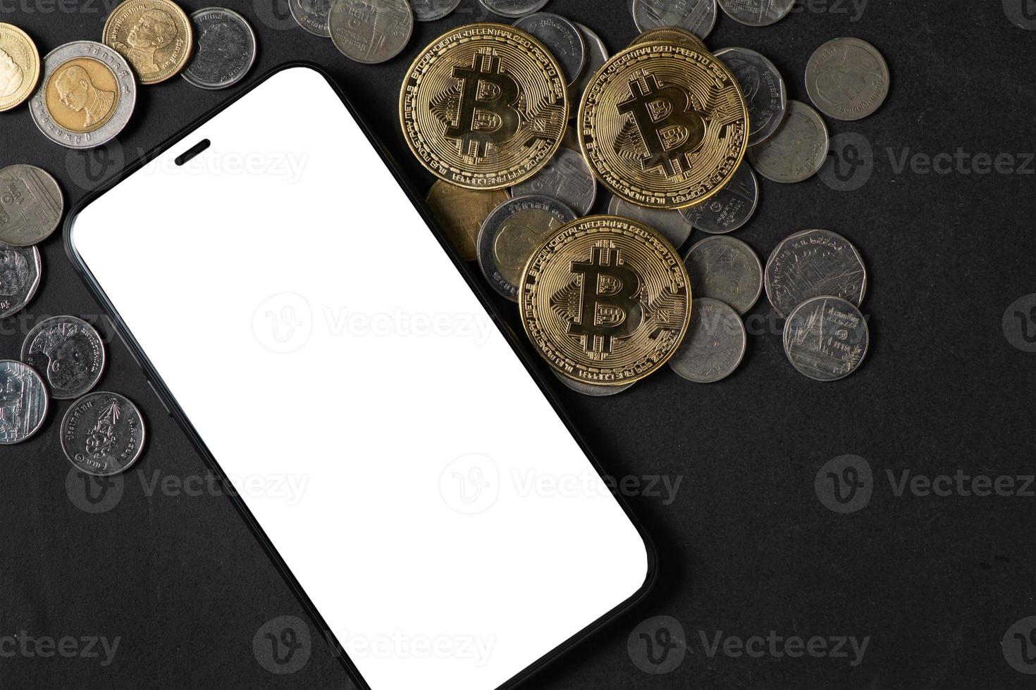 white screen smartphone and bitcoin on black stone table, photo