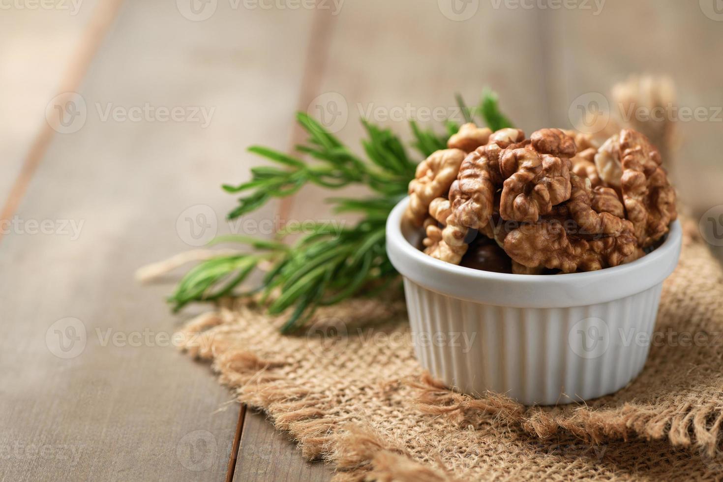 Walnut in white cup on wood background. healthy nuts concept. photo