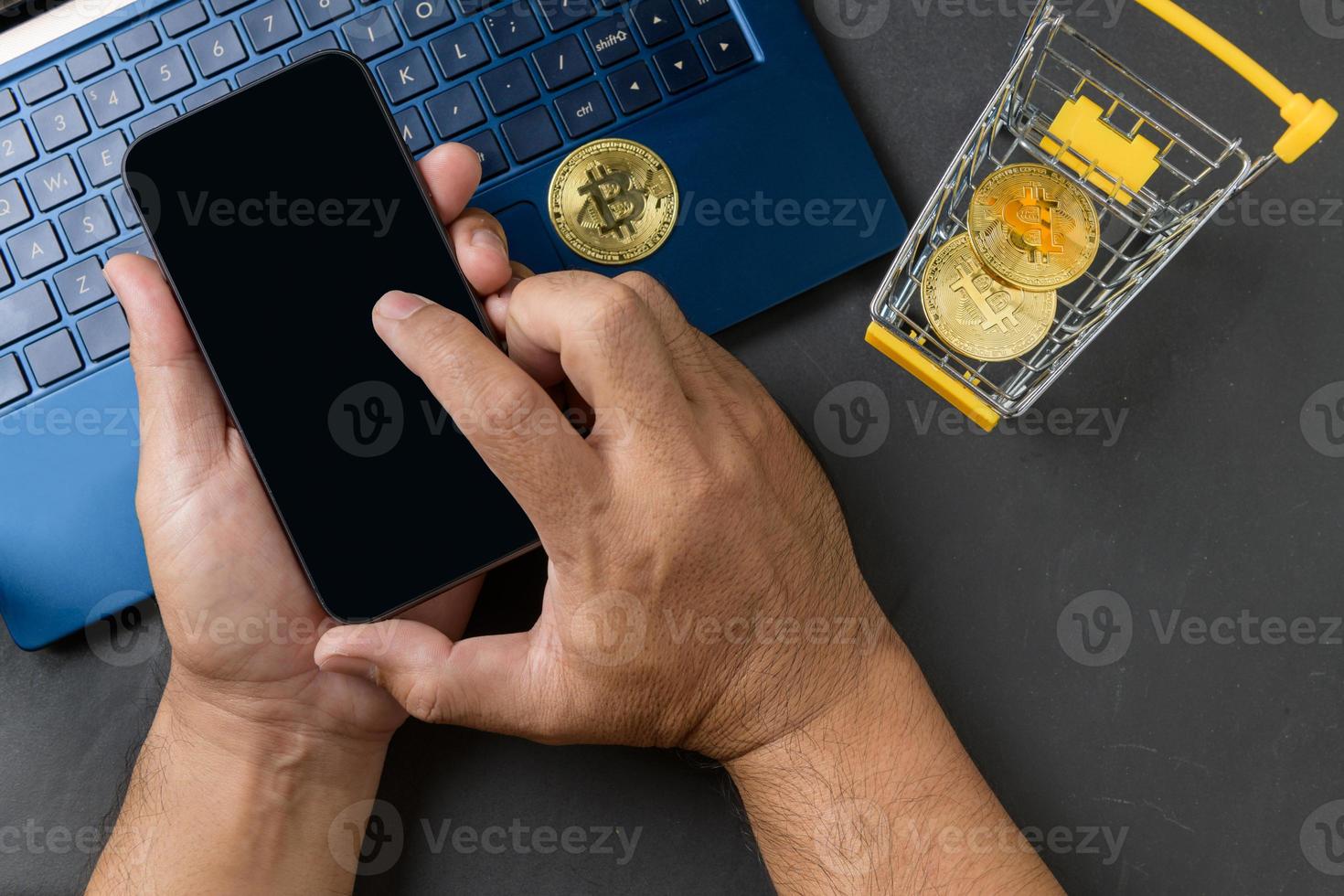 male hands using smartphone for sell or buy  virtual money, bit coin in yellow trolley photo