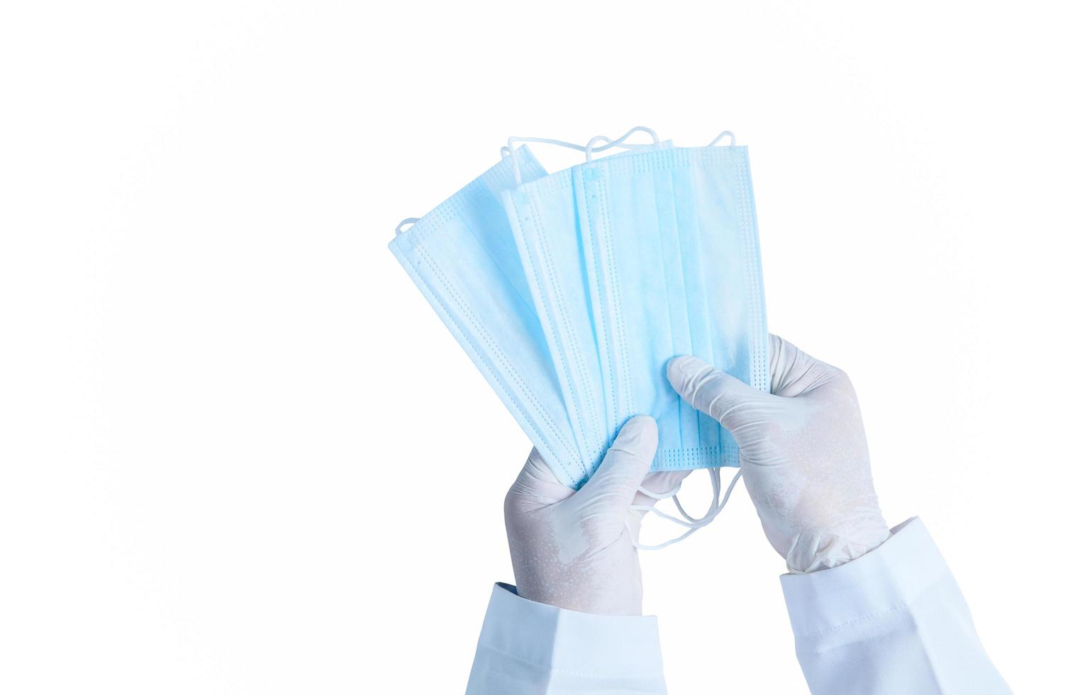 Doctor hands in medical gloves holding surgical  protective mask isolated photo