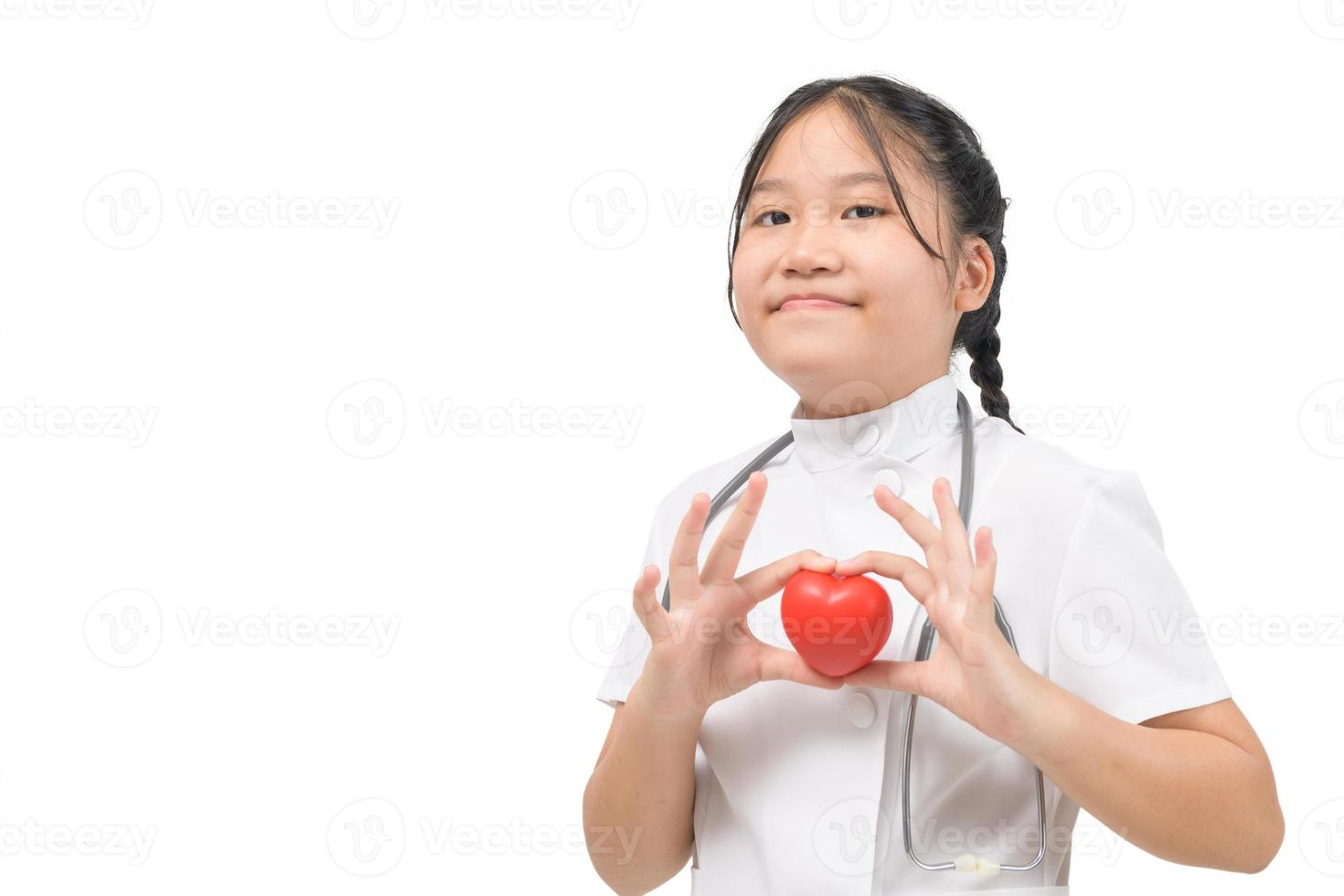 cute little girl doctor holding a red heart isolated on white background, photo