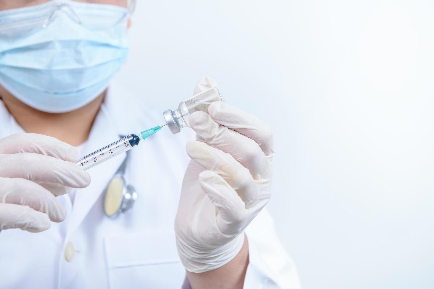 Doctor or scientist in gown shirt holding a syringe with liquid vaccines. medical and science concept photo