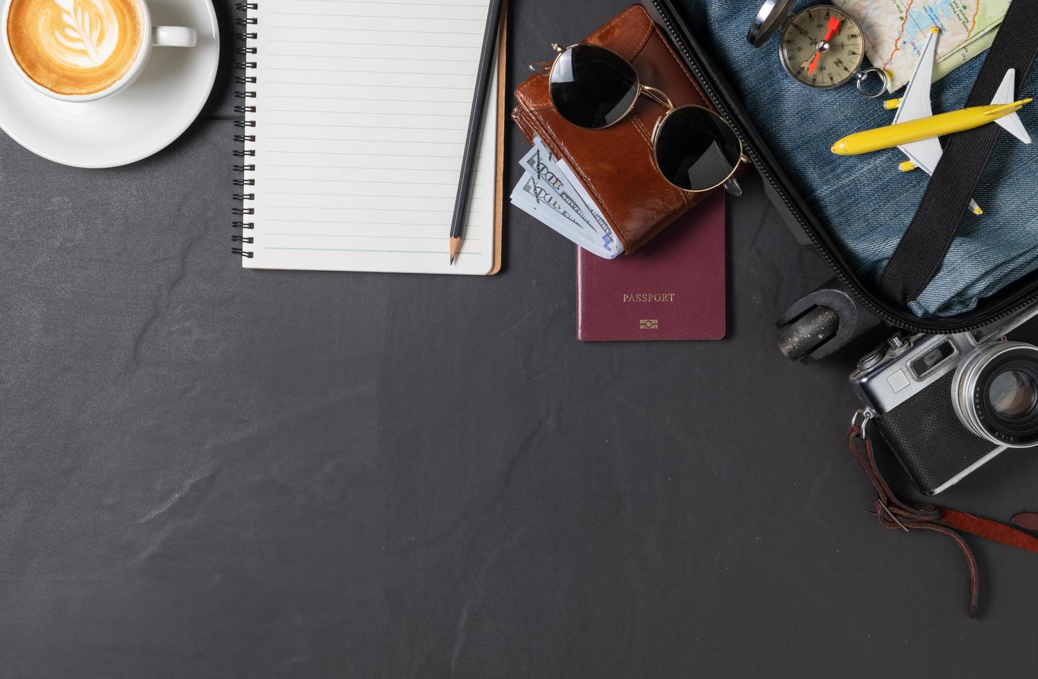 Prepare a suitcase,  vintage camera,  notebook, map and coffee photo