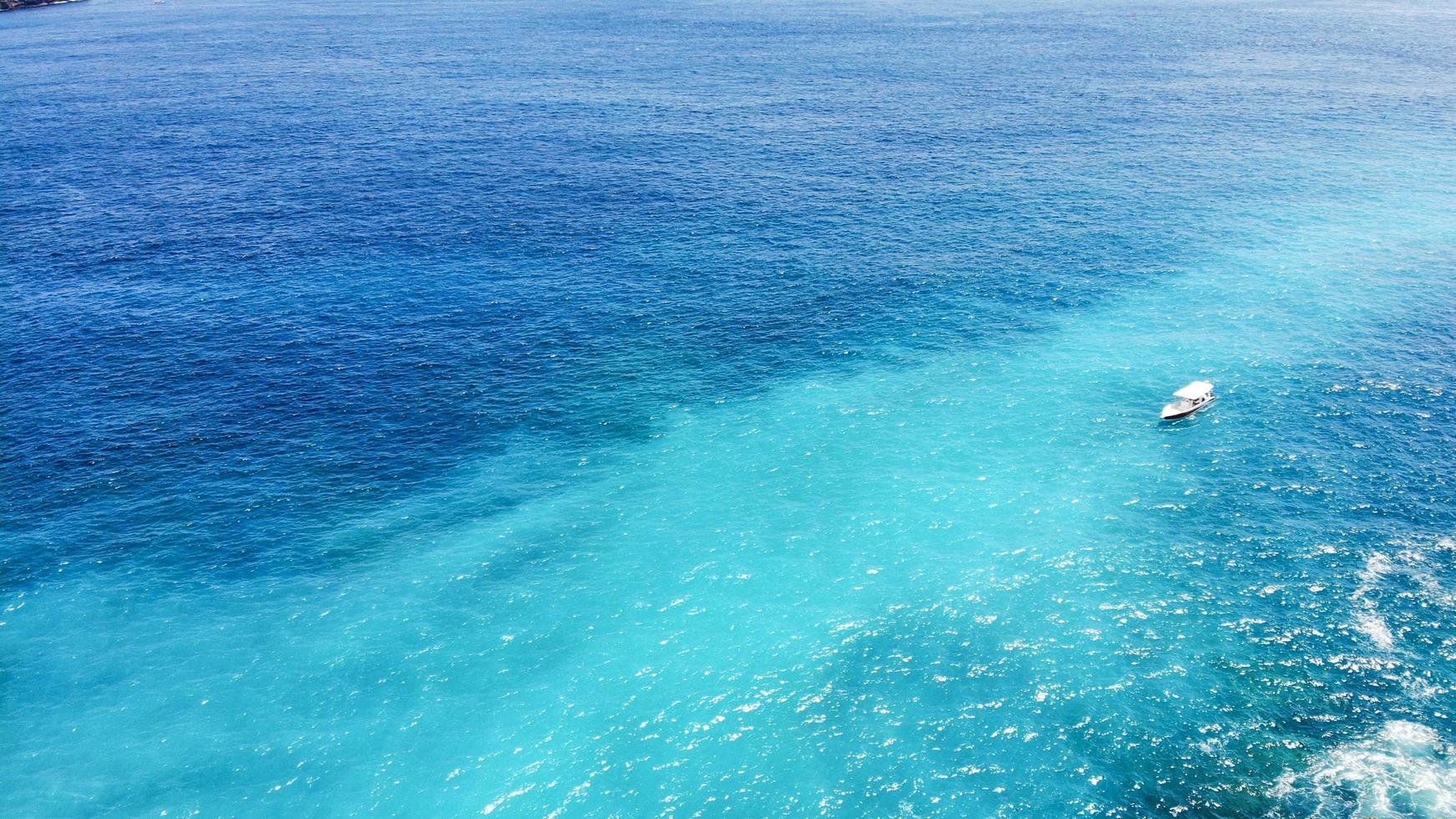 The sea water shimmers from dark blue to turquoise. photo