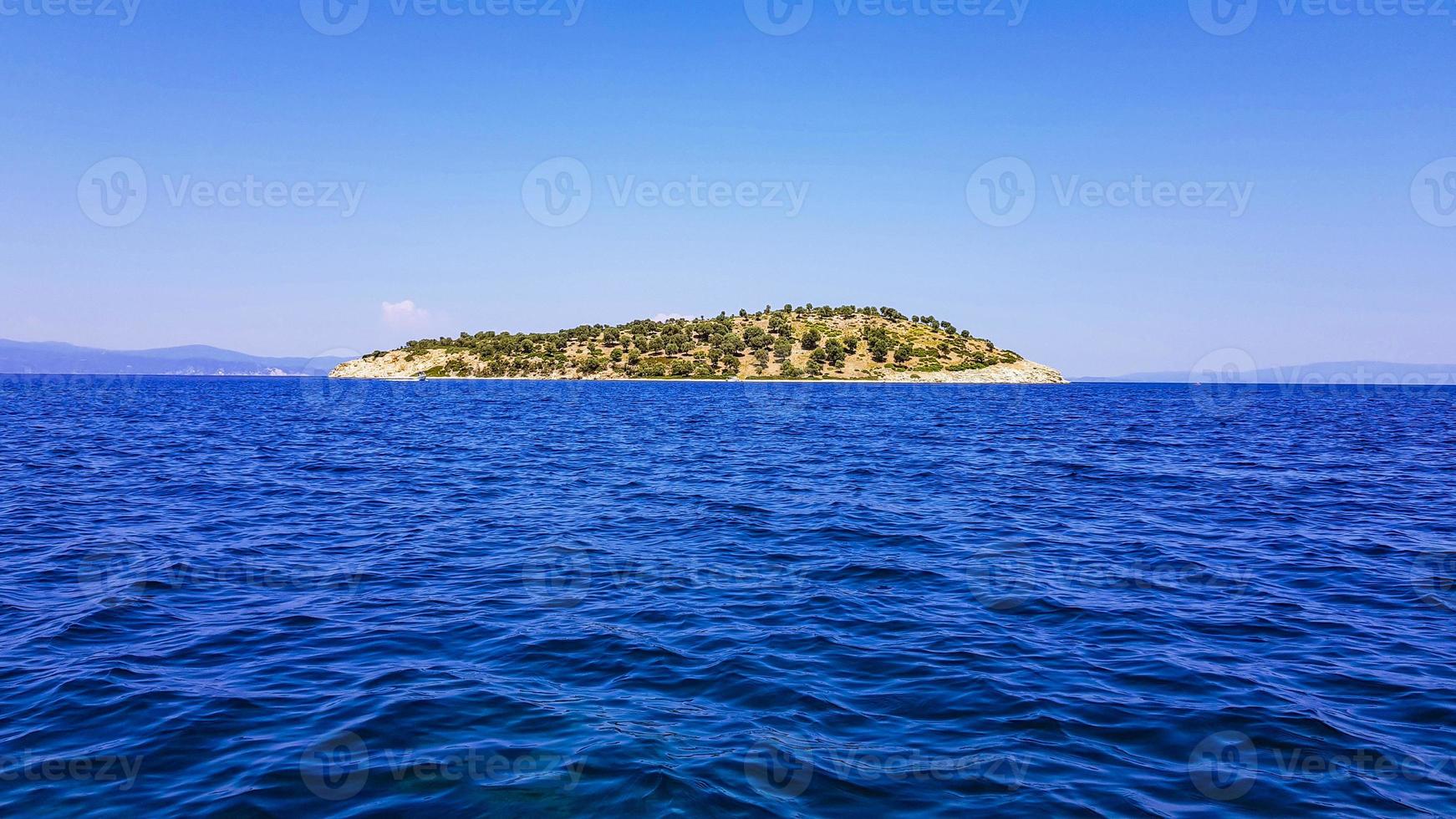 Dark blue sea, in the center of an uninhabited island. photo