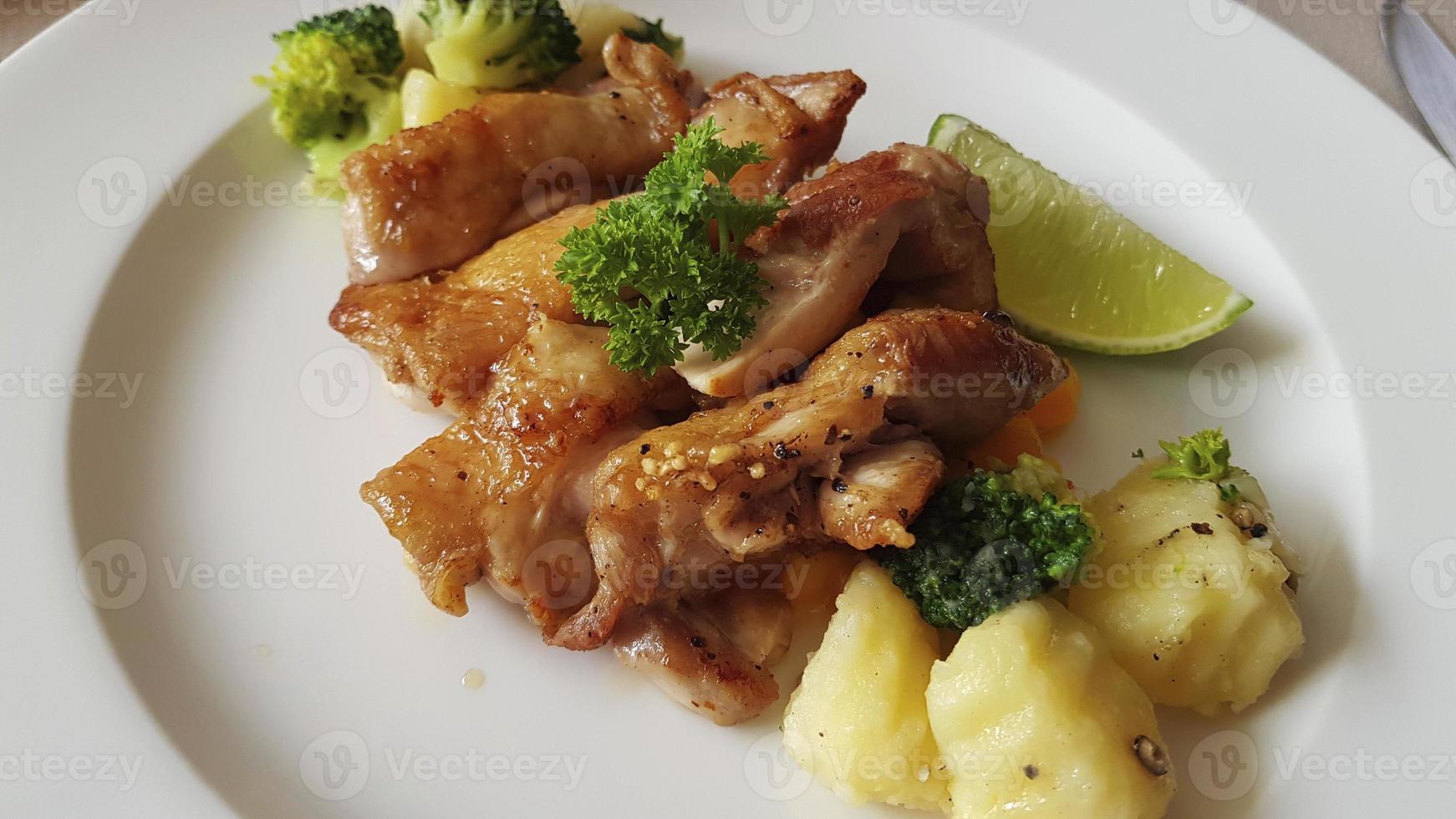 A la parrilla piezas de pollo con vegetales en blanco lámina. pedazo de Lima. foto