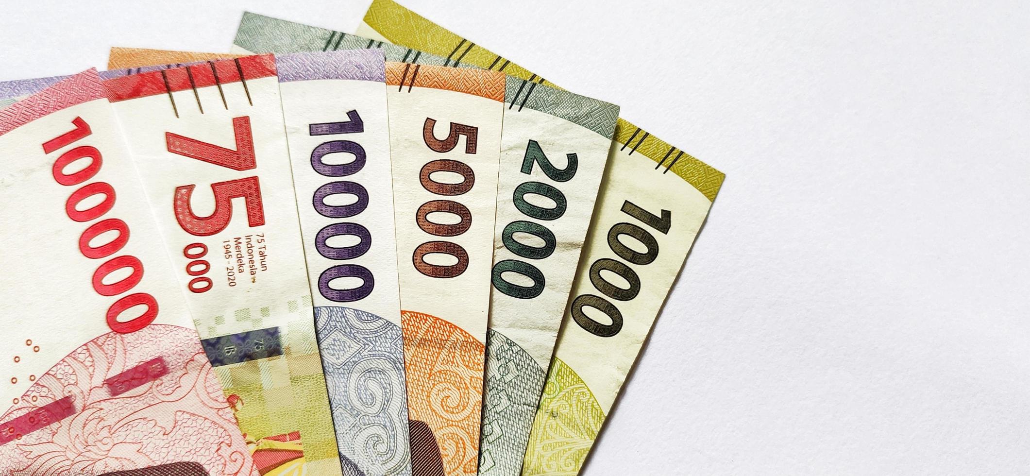 New Indonesian banknotes issued in 2022 in various colors and sizes. Rupiah currency concept isolated on a white background. Negative space and top view. photo