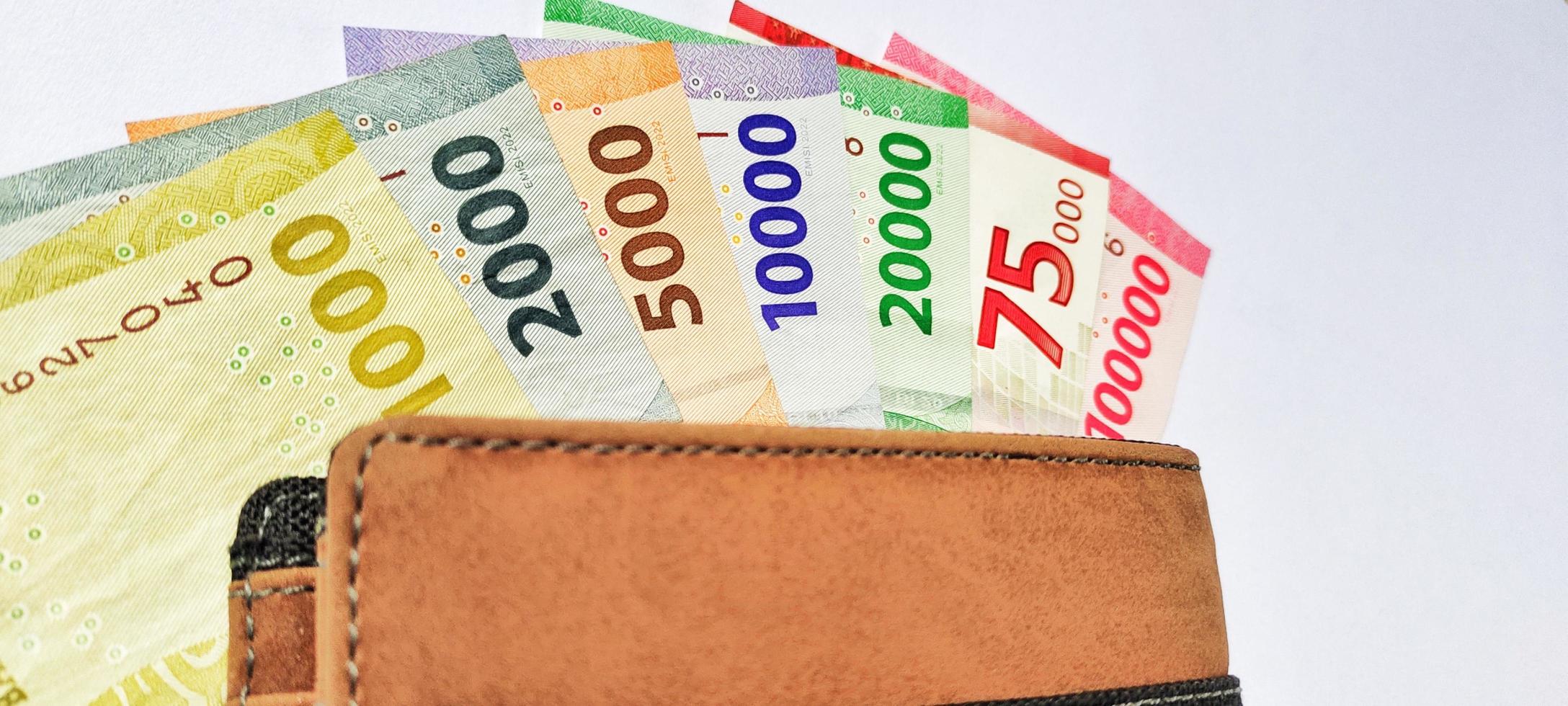 A wallet containing new Indonesian banknotes issued in 2022. Rupiah currency concept isolated on a white background. Negative space photo