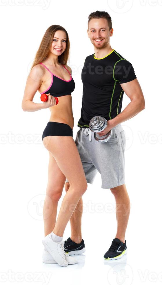 Athletic man and woman with dumbbells on the white photo