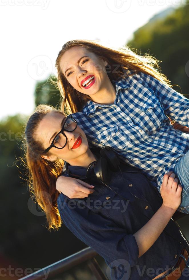 Two playful young women having fun outdoors photo