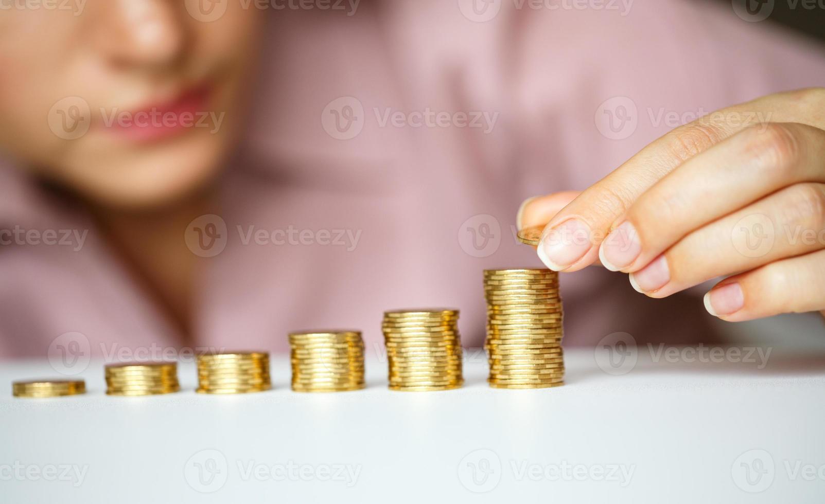 mujer apilado oro monedas dentro creciente columnas foto