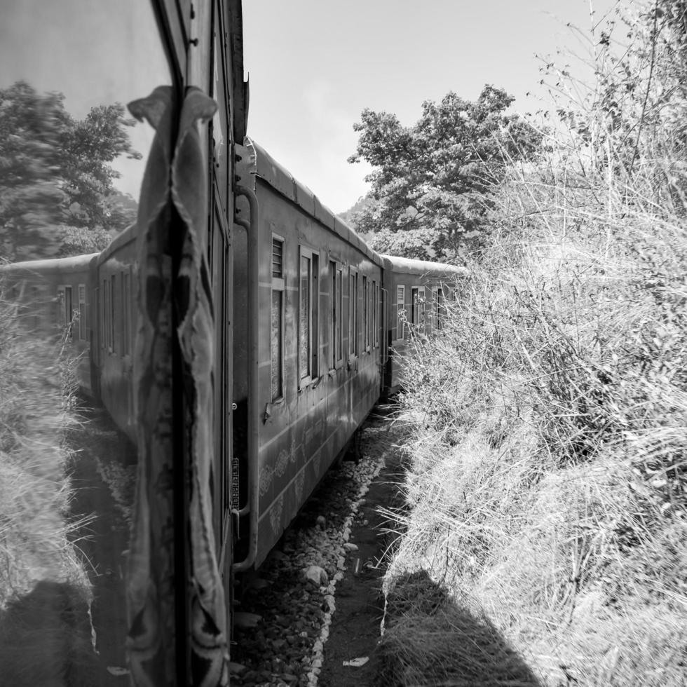 tren de juguete moviéndose en las laderas de las montañas, hermosa vista, una montaña lateral, un valle lateral moviéndose en ferrocarril hacia la colina, entre bosques naturales verdes. tren de juguete de kalka a shimla en india, tren indio foto