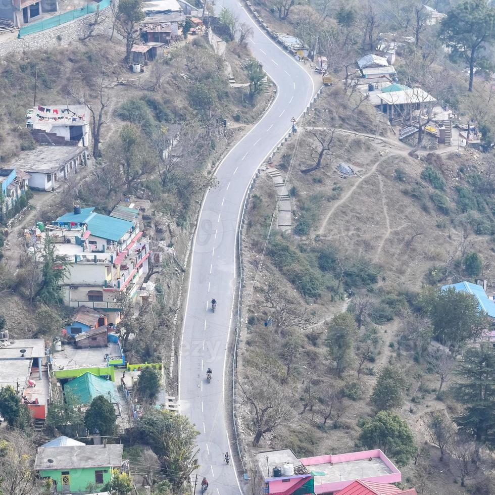 Aerial top view of traffic vehicles driving at mountains roads at Nainital, Uttarakhand, India, View from the top side of mountain for movement of traffic vehicles photo