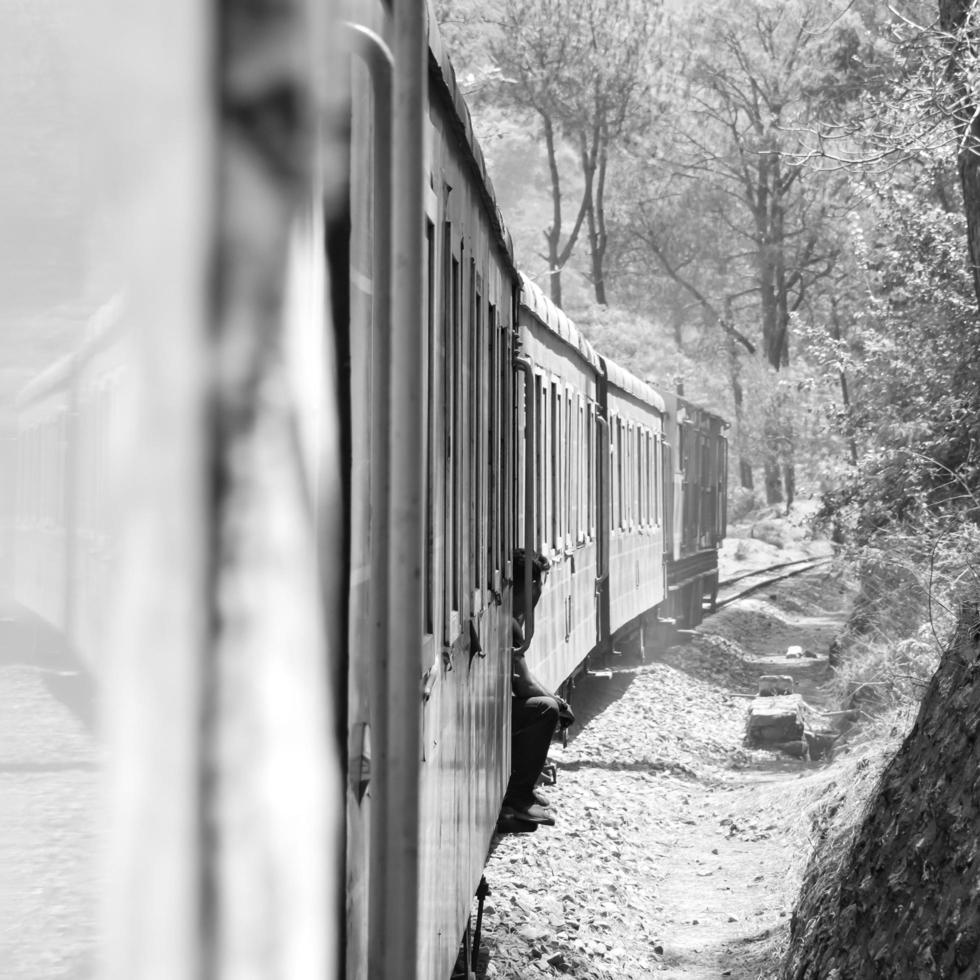 Toy Train moving on mountain slopes, beautiful view, one side mountain, one side valley moving on railway to the hill, among green natural forest. Toy train from Kalka to Shimla in India, Indian Train photo