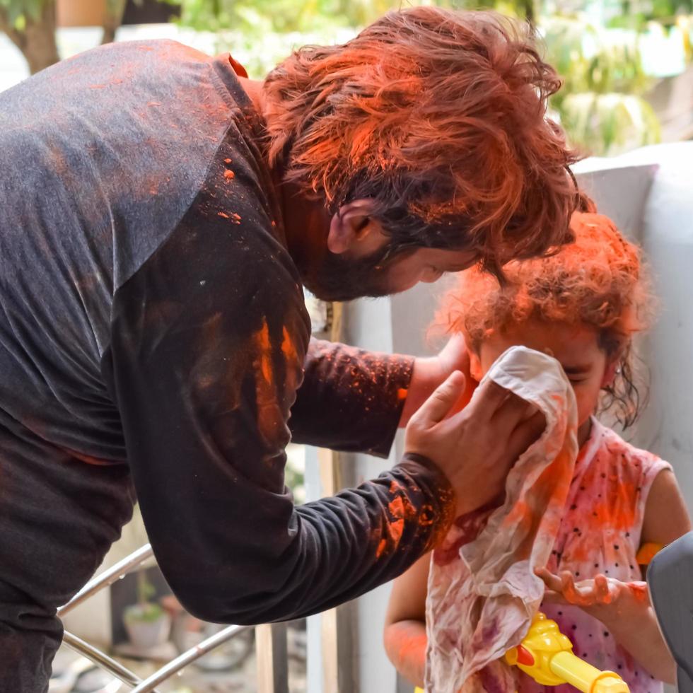 Indian family people playing colours on Holi festival, holding different colours, Holi festival celebrations in Delhi, India photo