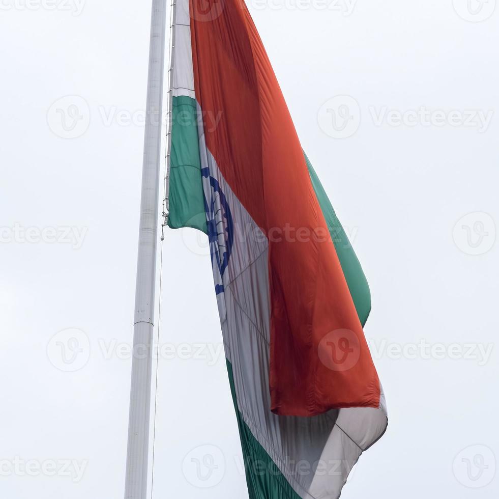India flag flying high at Connaught Place with pride in blue sky, India flag fluttering, Indian Flag on Independence Day and Republic Day of India, tilt up shot, Waving Indian flag, Har Ghar Tiranga photo