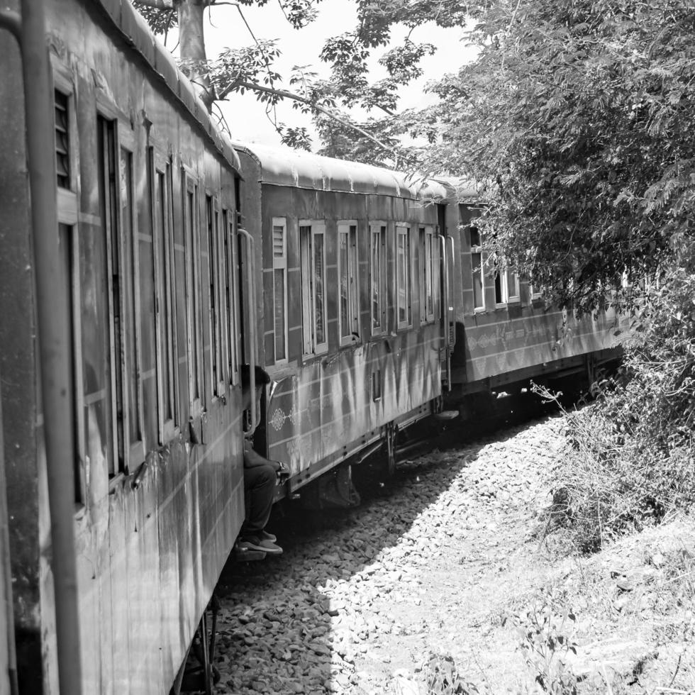 Toy Train moving on mountain slopes, beautiful view, one side mountain, one side valley moving on railway to the hill, among green natural forest. Toy train from Kalka to Shimla in India, Indian Train photo