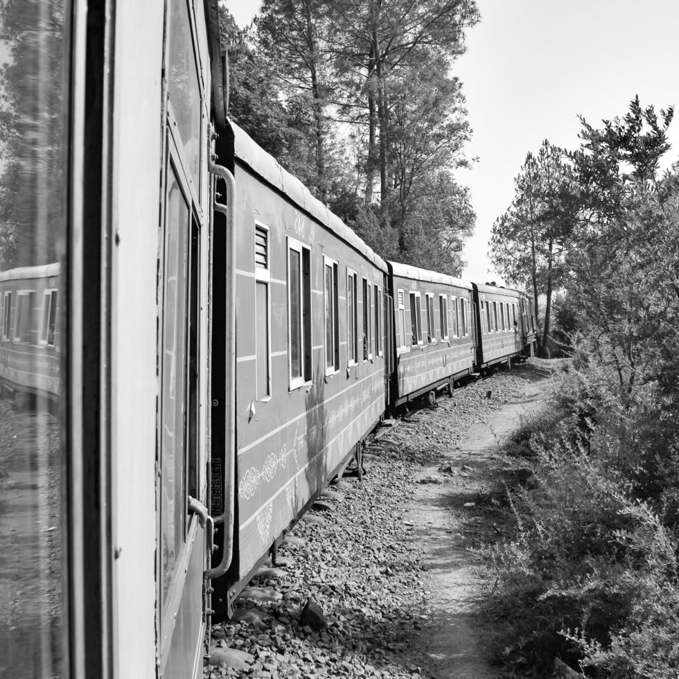 Toy Train moving on mountain slopes, beautiful view, one side mountain, one side valley moving on railway to the hill, among green natural forest. Toy train from Kalka to Shimla in India, Indian Train photo