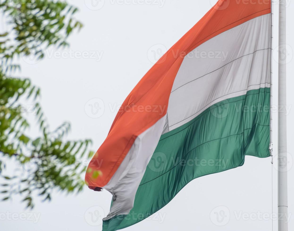 India flag flying high at Connaught Place with pride in blue sky, India flag fluttering, Indian Flag on Independence Day and Republic Day of India, tilt up shot, Waving Indian flag, Har Ghar Tiranga photo