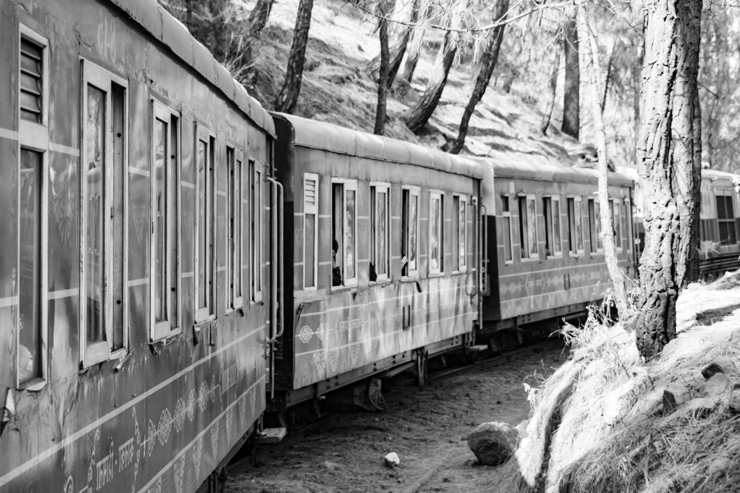 Toy Train moving on mountain slopes, beautiful view, one side mountain, one side valley moving on railway to the hill, among green natural forest. Toy train from Kalka to Shimla in India, Indian Train photo