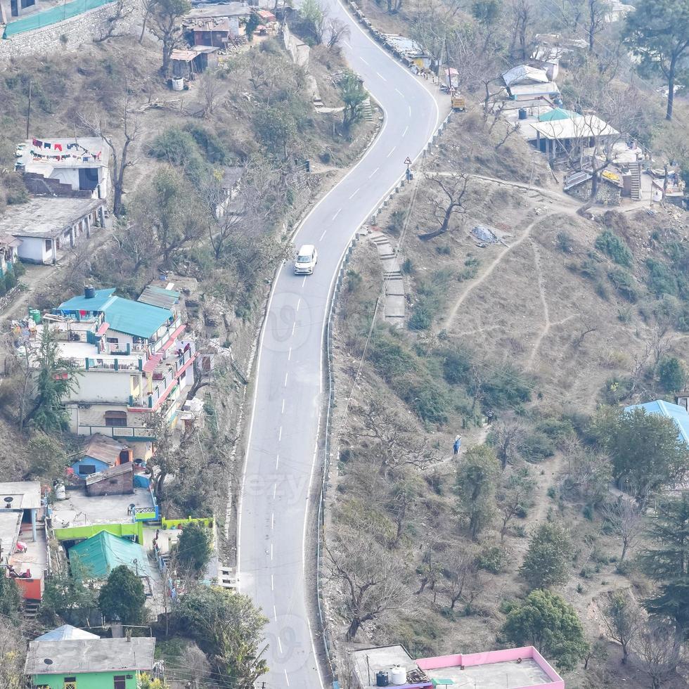 Aerial top view of traffic vehicles driving at mountains roads at Nainital, Uttarakhand, India, View from the top side of mountain for movement of traffic vehicles photo