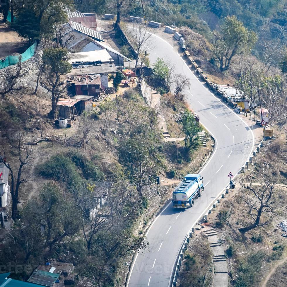 Aerial top view of traffic vehicles driving at mountains roads at Nainital, Uttarakhand, India, View from the top side of mountain for movement of traffic vehicles photo