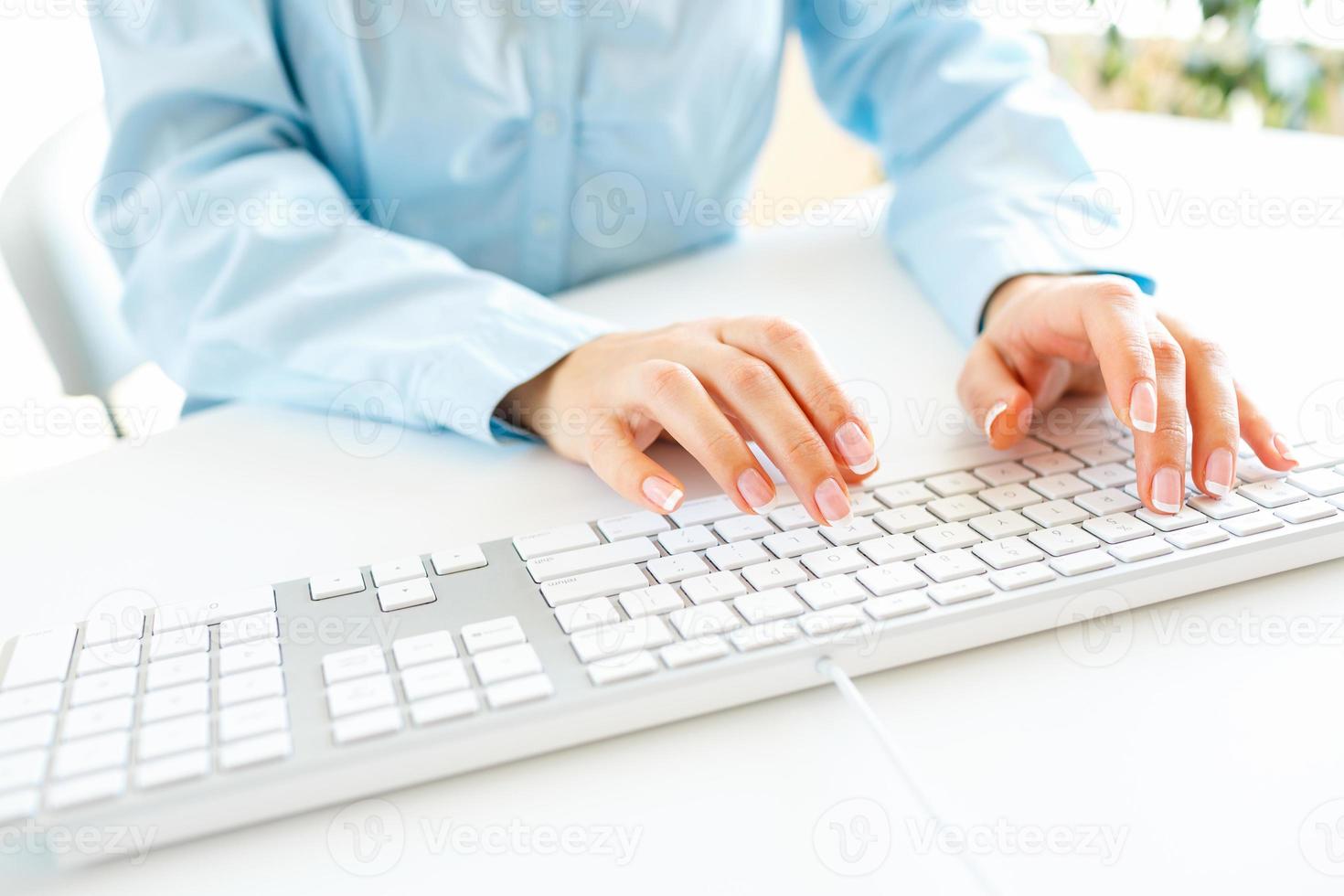 Woman office worker typing on the keyboard photo