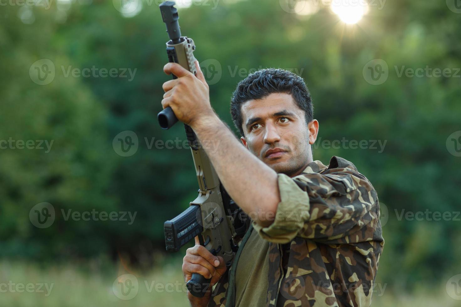 joven masculino soldado con máquina pistola foto