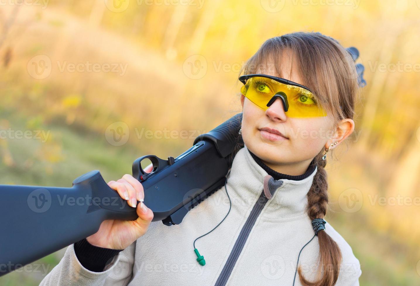 Young beautiful girl with a shotgun photo