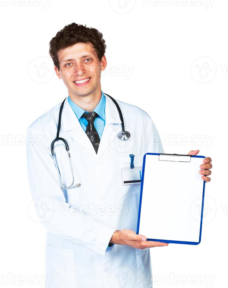 Young male smiling doctor showing clipboard on white photo